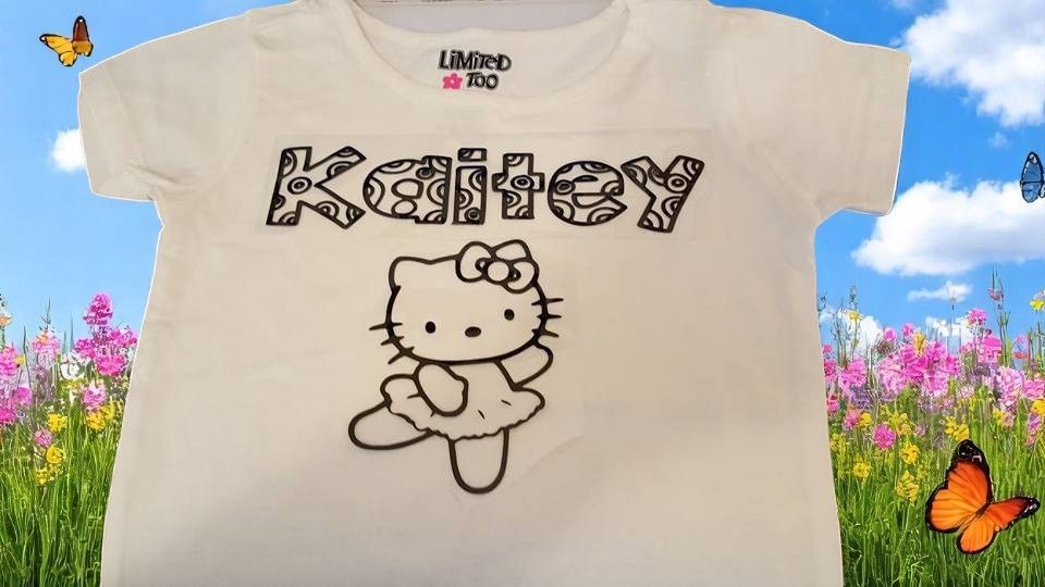 A white t-shirt featuring a Hello Kitty graphic and the name 