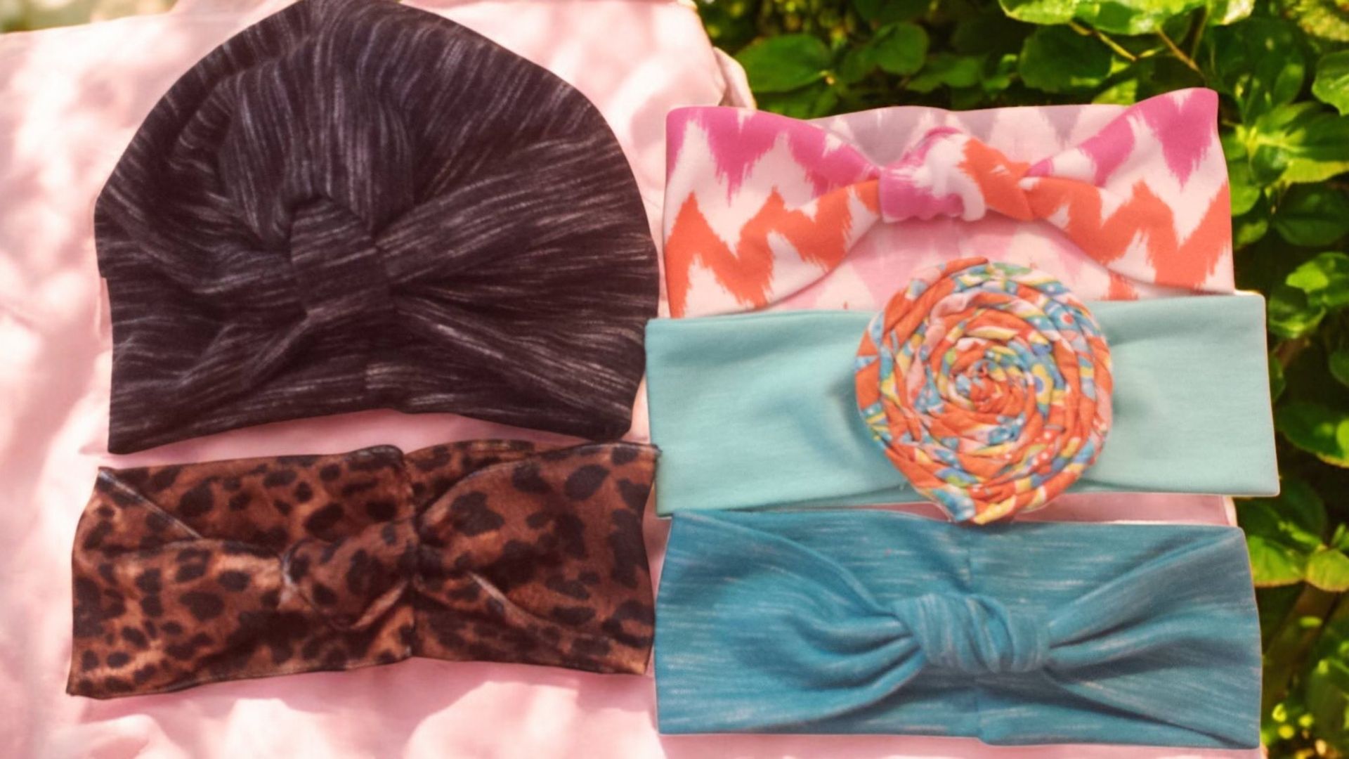 A selection of five soft headbands and a turban hat in various colors and patterns, including leopard print and zigzags.