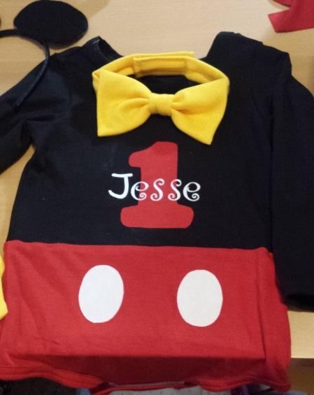 A Mickey Mouse-themed toddler outfit with a black shirt, red shorts, 