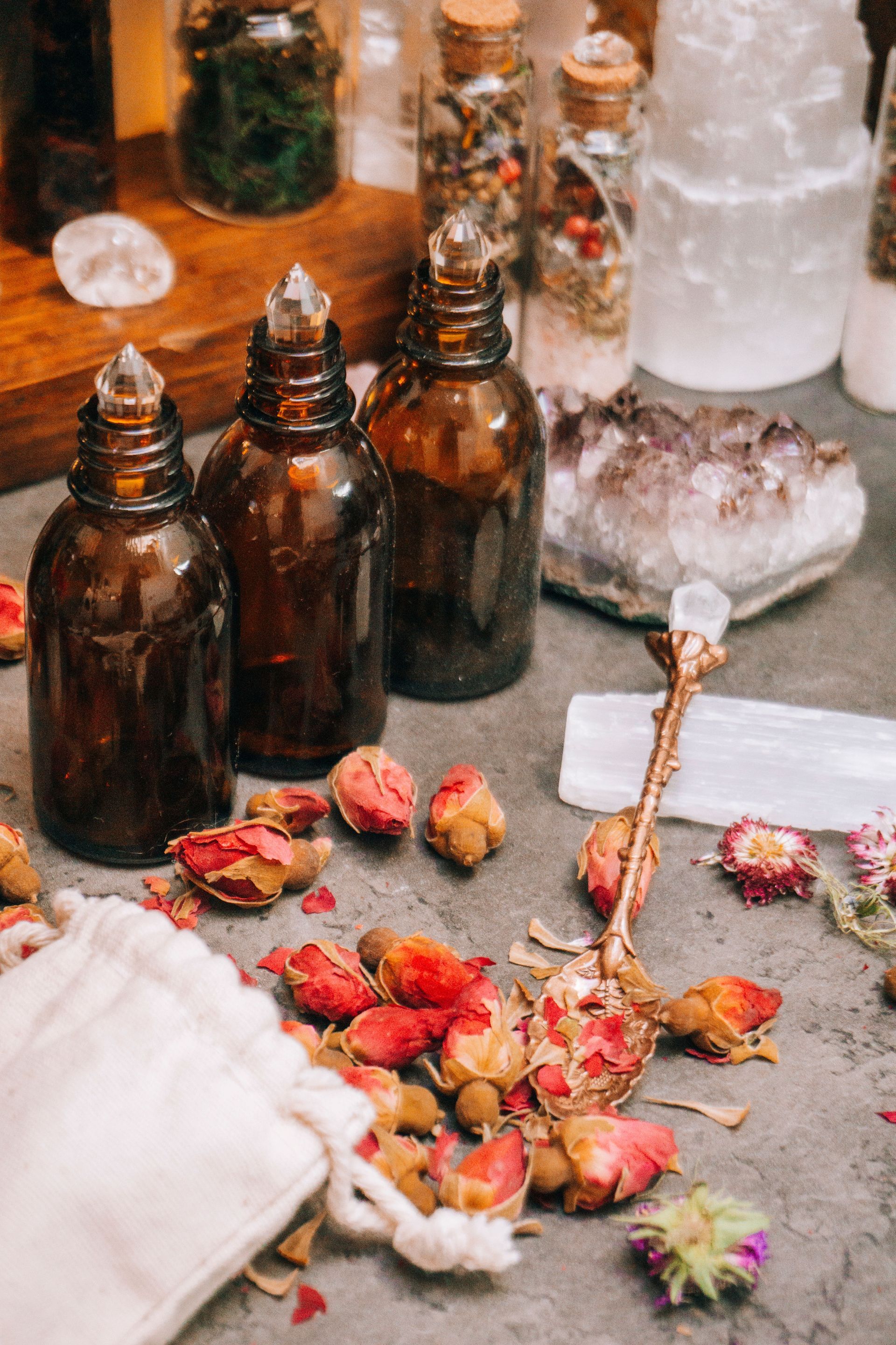 Amber bottles and dried flowers on a table with a glass dispenser and white cloths
