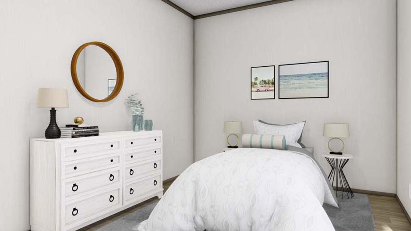 A bedroom with a bed , dresser , mirror and lamps.