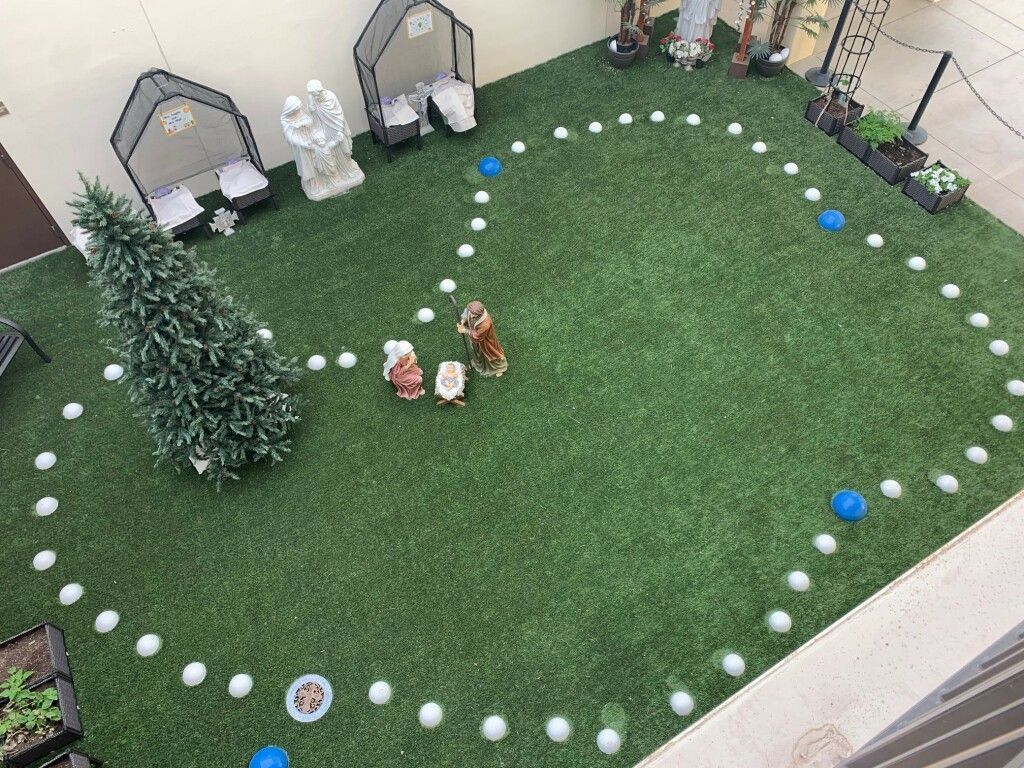 Backyard miniature golf green with white and blue markers, small decorations, and potted plants