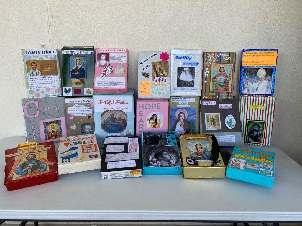 Assorted colorful boxed cards and small books arranged on a table against a plain wall.