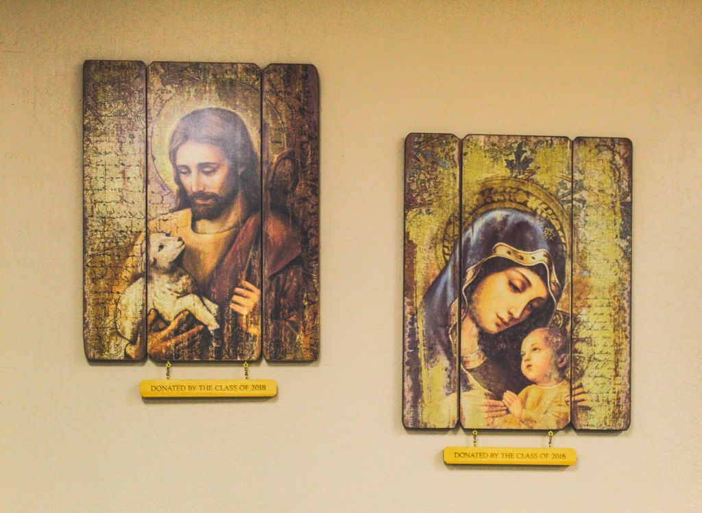 Two religious wall plaques with painted saints, one of a bearded man and one of a mother holding a child.