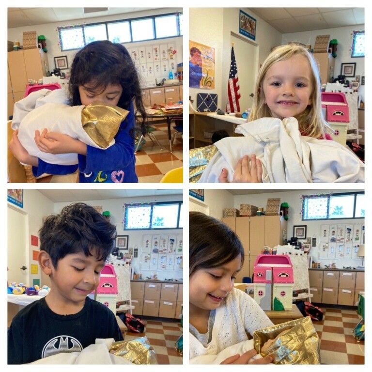 Children in a classroom holding wrapped gifts and smiling during a celebration