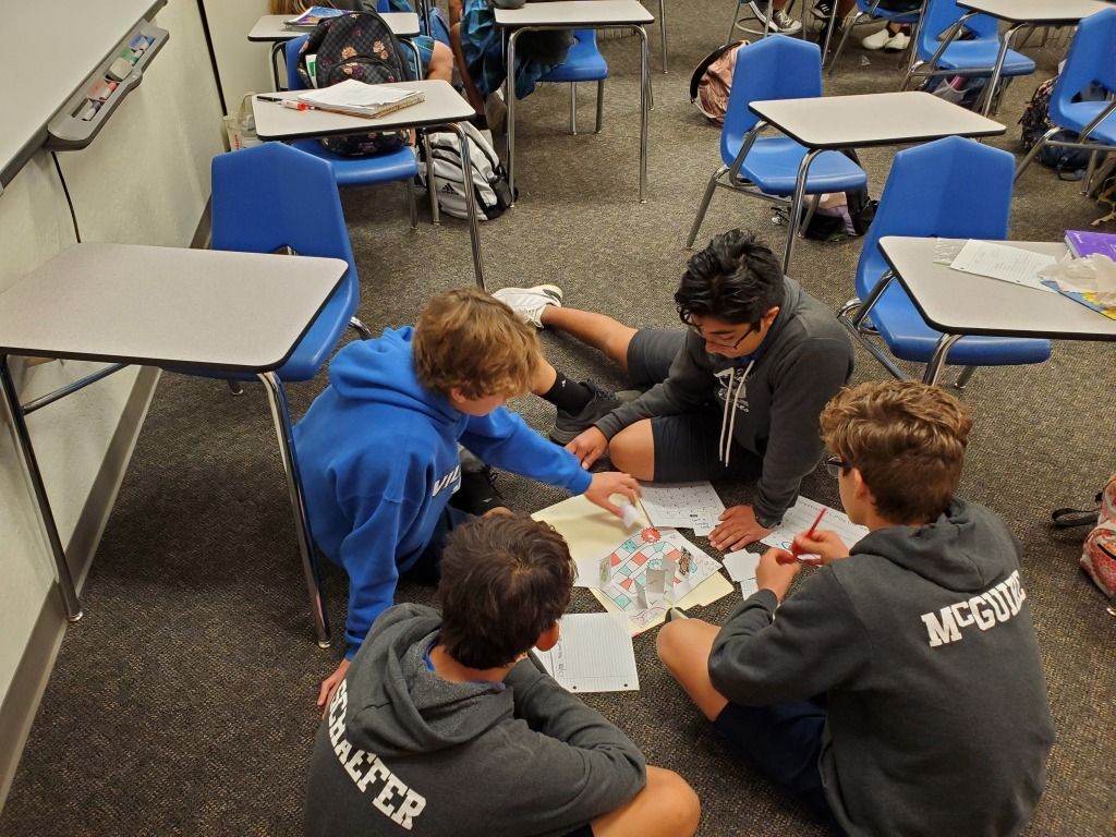 Students gathered around a table in a classroom, working together on an activity.
