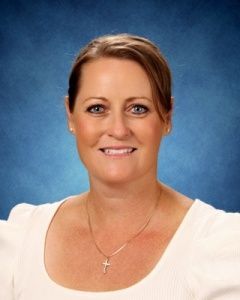 Smiling woman in a white blouse against a blue studio backdrop