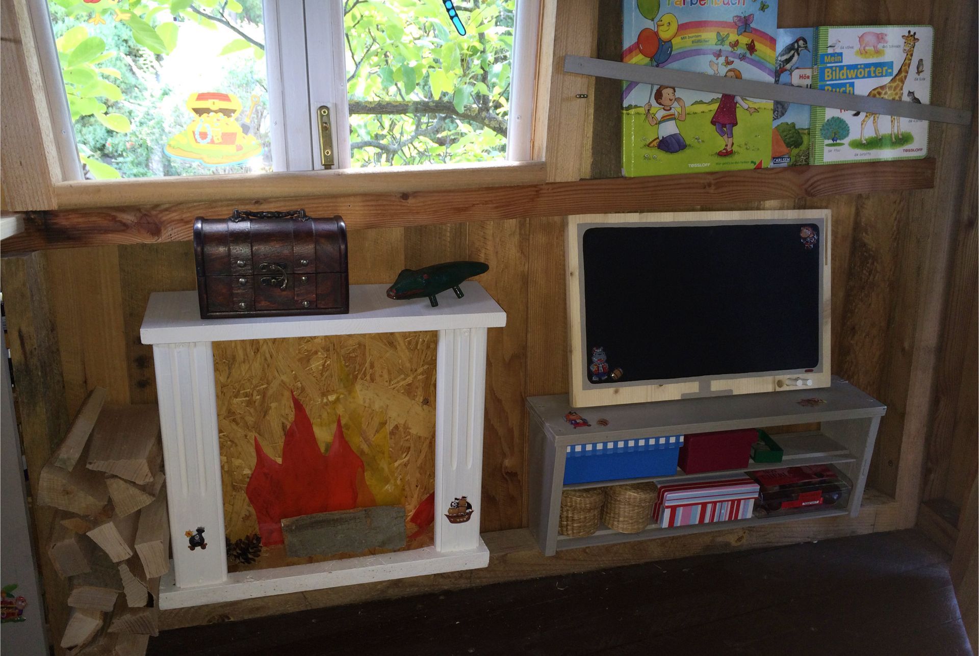 Spielbereich im Baumhaus mit dekorativem Kamin und Stauraumlösungen
