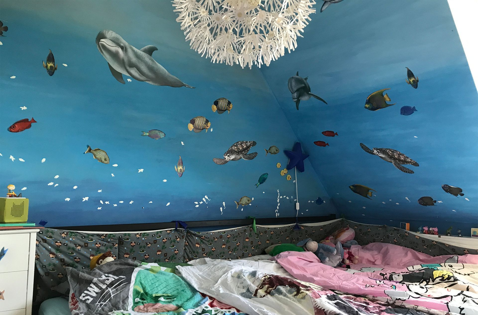 Kinderzimmer mit Unterwasserwelt und individuell gestalteter Wand- und Deckengestaltung mit Delfinen, Fischen und Schildkröten.