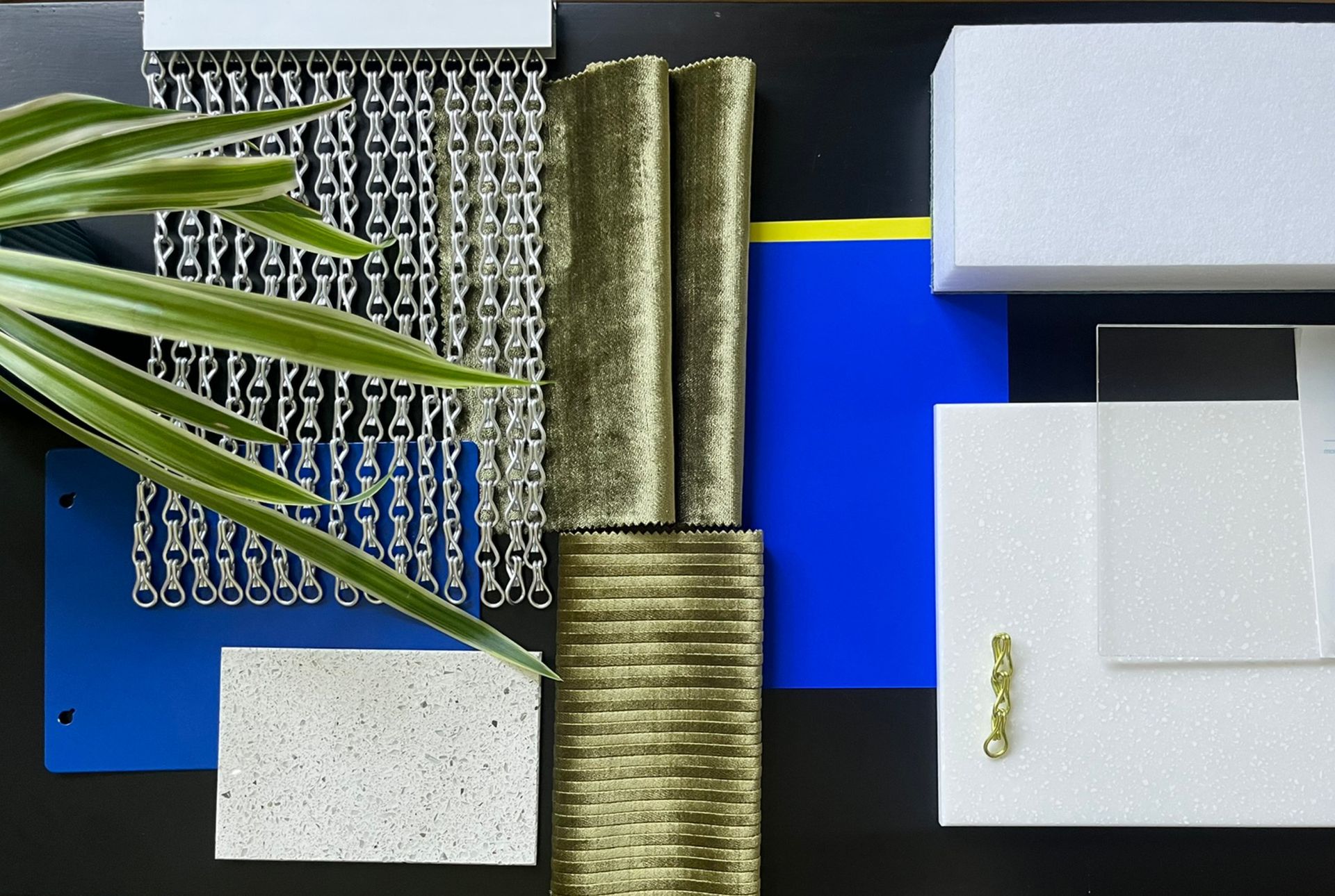 Materialcollage mit International Blue, Stoffmustern in grün und metallischen Ketten in silber & lemone für modernes Frisörsalon Interior Design