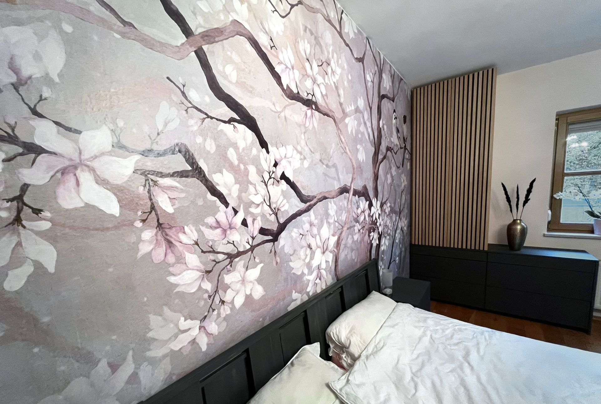 Detailansicht der floralen Designtapete hinter dem Bett mit abgestimmten Farben und modernem Schlafzimmerkonzept