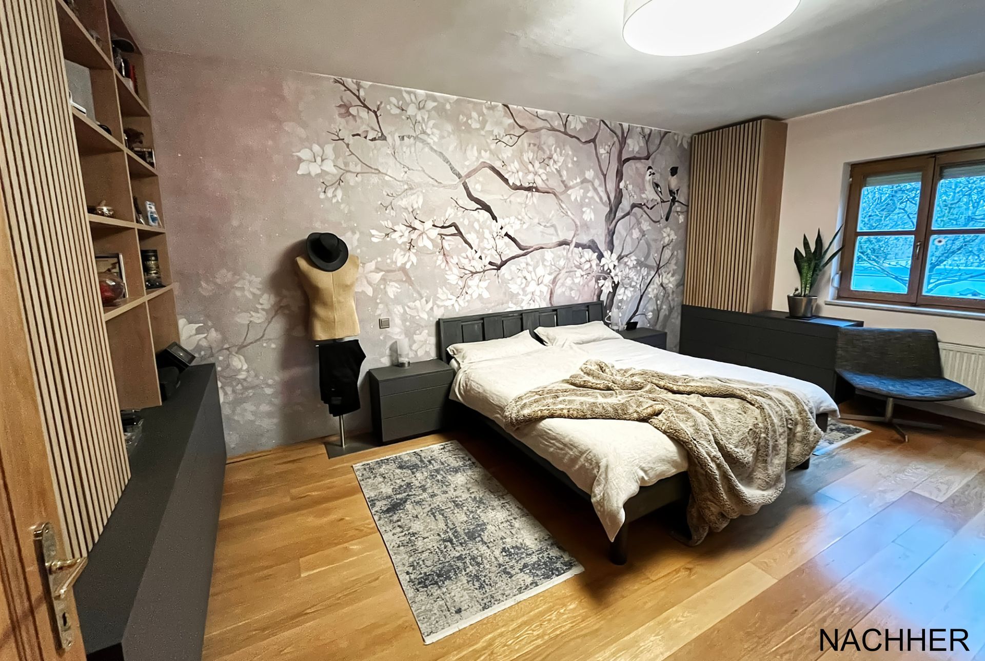 Modernes Schlafzimmerdesign mit floraler Designtapete, maßgefertigten Lamellenmöbeln in Eiche und anthrazitfarbenen Stauraumlösungen