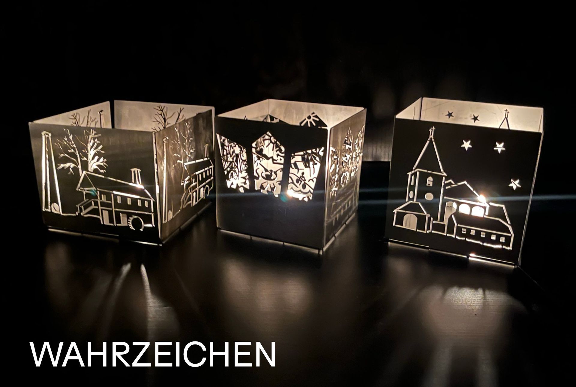 Drei beleuchtete Metalllaternen, verziert mit Stadtszenen, werfen Schatten auf eine dunkle Fläche;