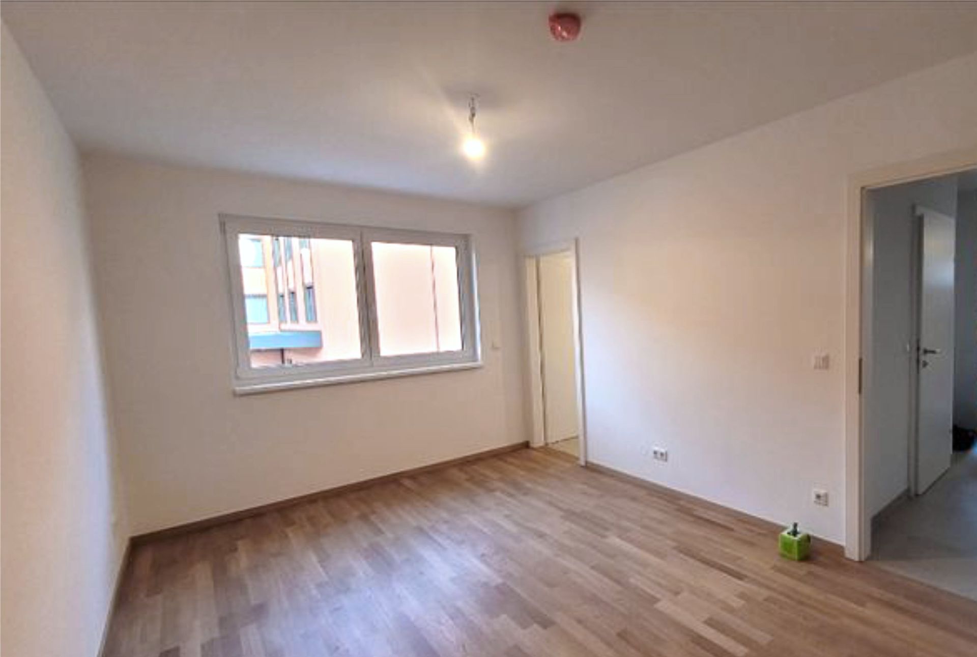 Vorher-Situation der Praxisräume mit hellem Holzboden, weißen Wänden und leerem Behandlungsraum in Wiener Neustadt
