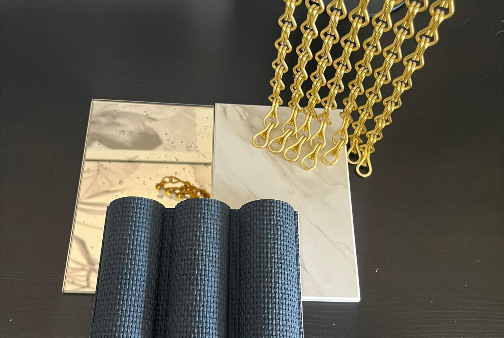 Moodboard für luxuriöses Interior Design eines Tabakfachgeschäfts mit goldfarbenem Kettenvorhang und dunkler Materialwelt