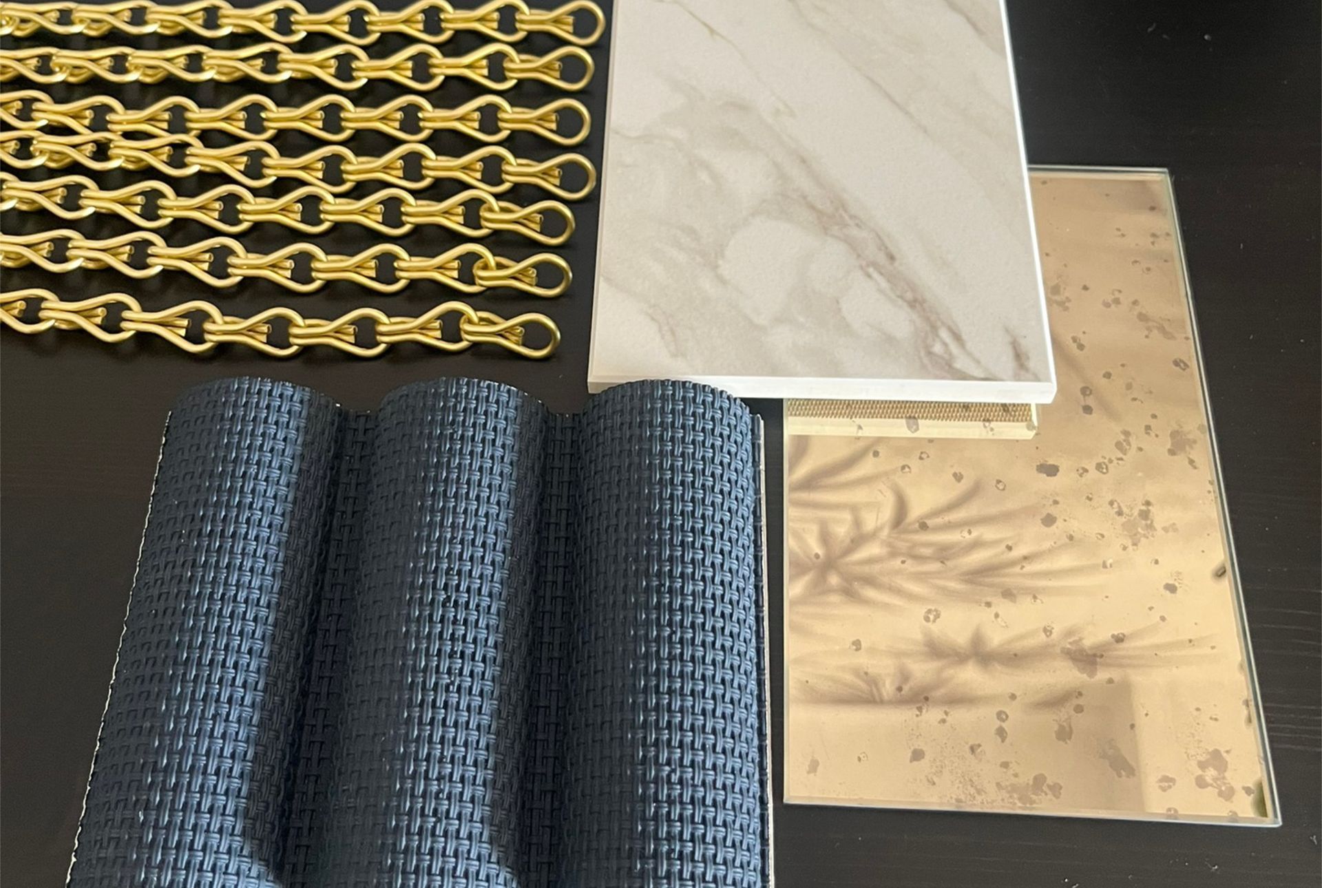 Materialkonzept für elegantes Ladenbauprojekt mit Marmoroptik, Messingdetails und dunkelblauen Stoffmustern