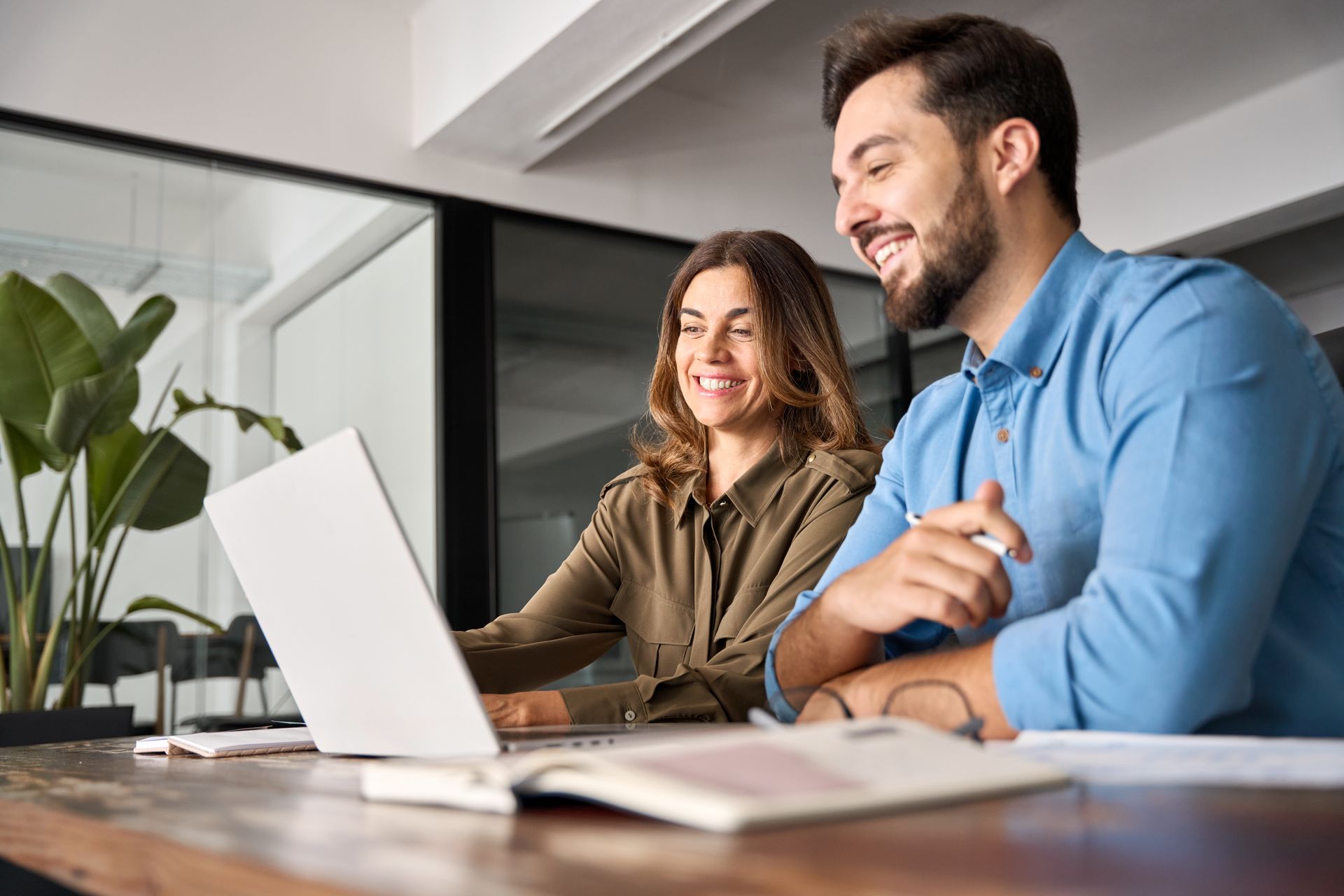 Two people collaborating through a laptop