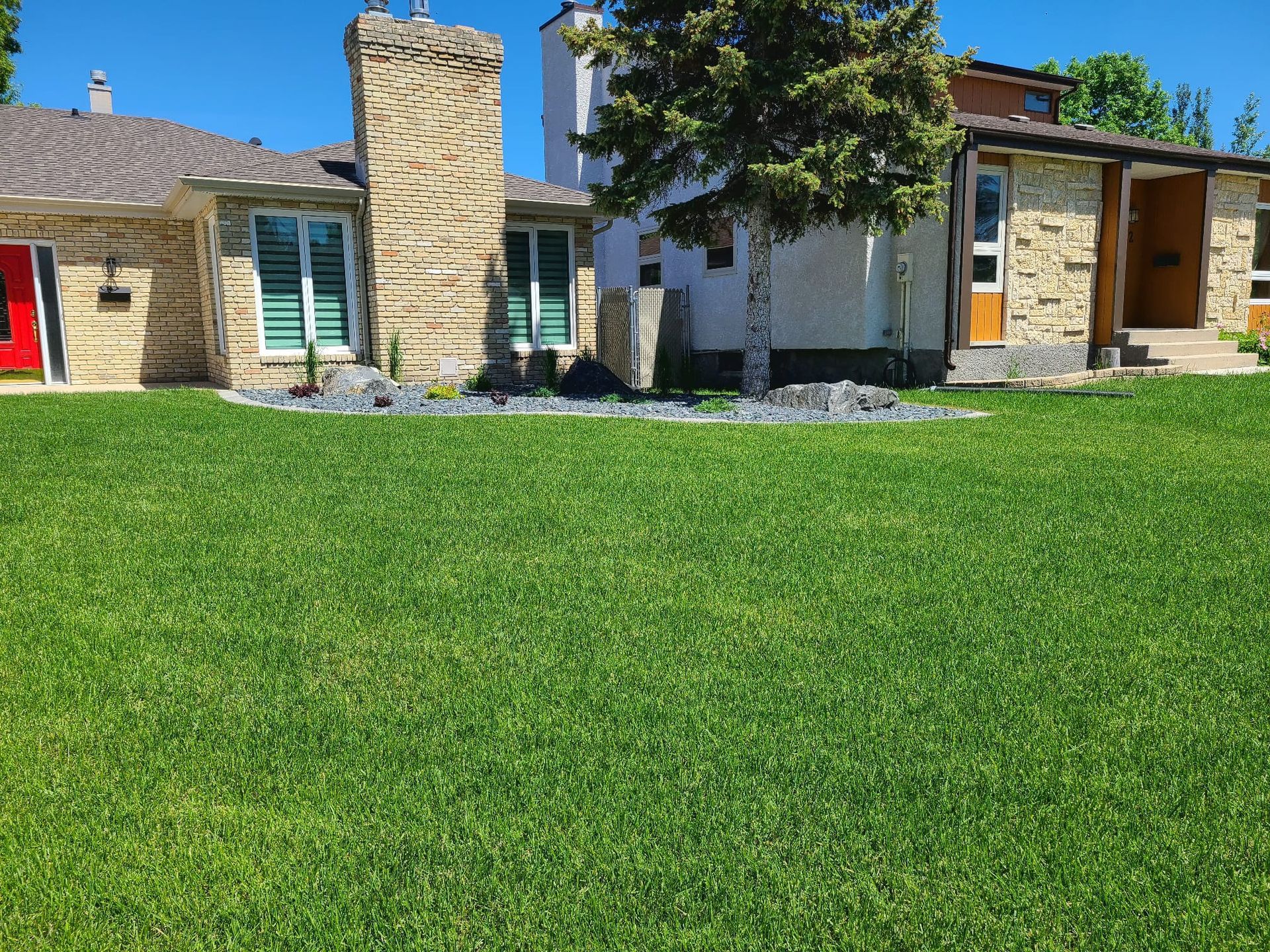 A house with a large lush green lawn in front of it.