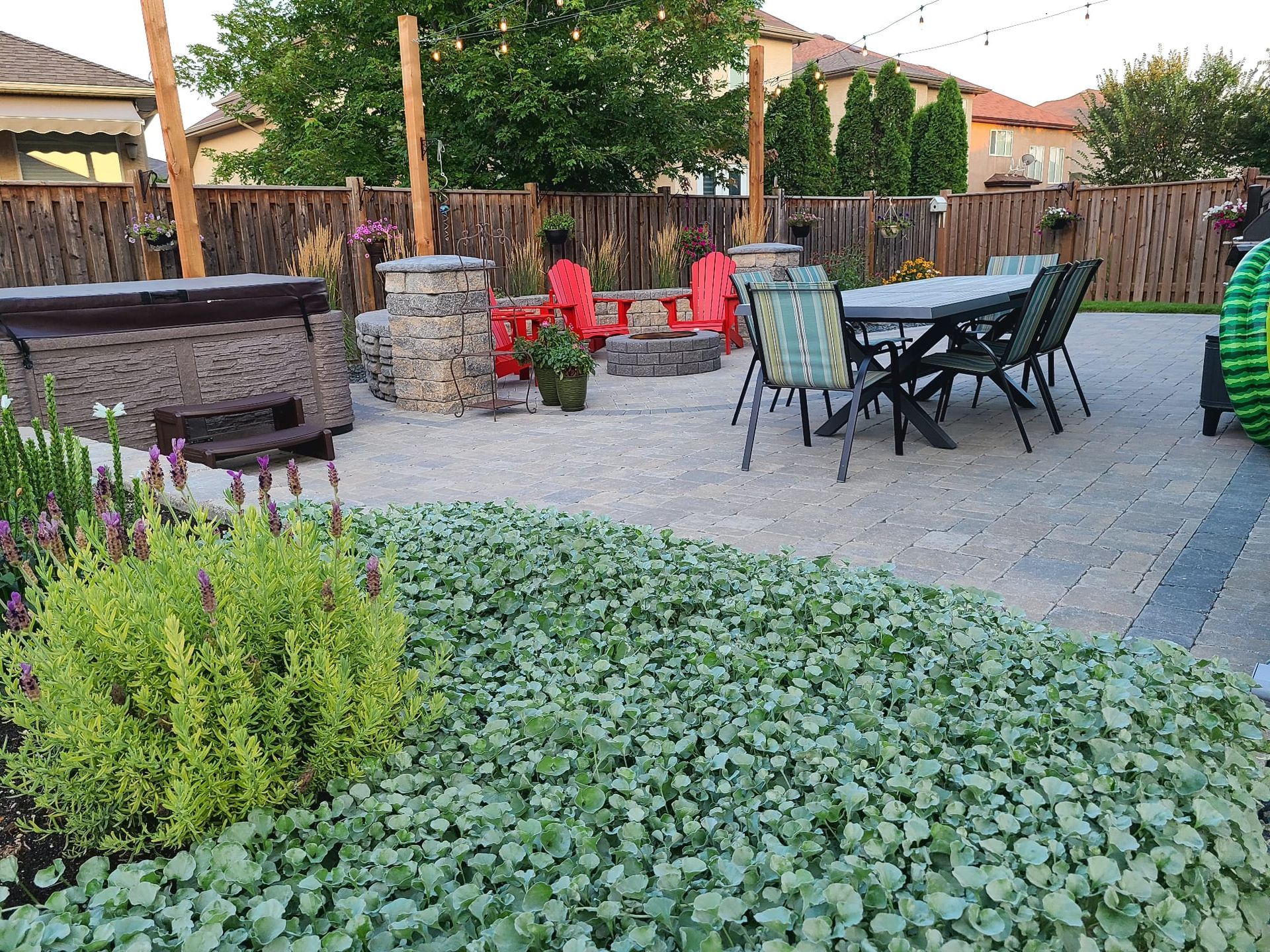 A patio with a table and chairs and a fire pit.
