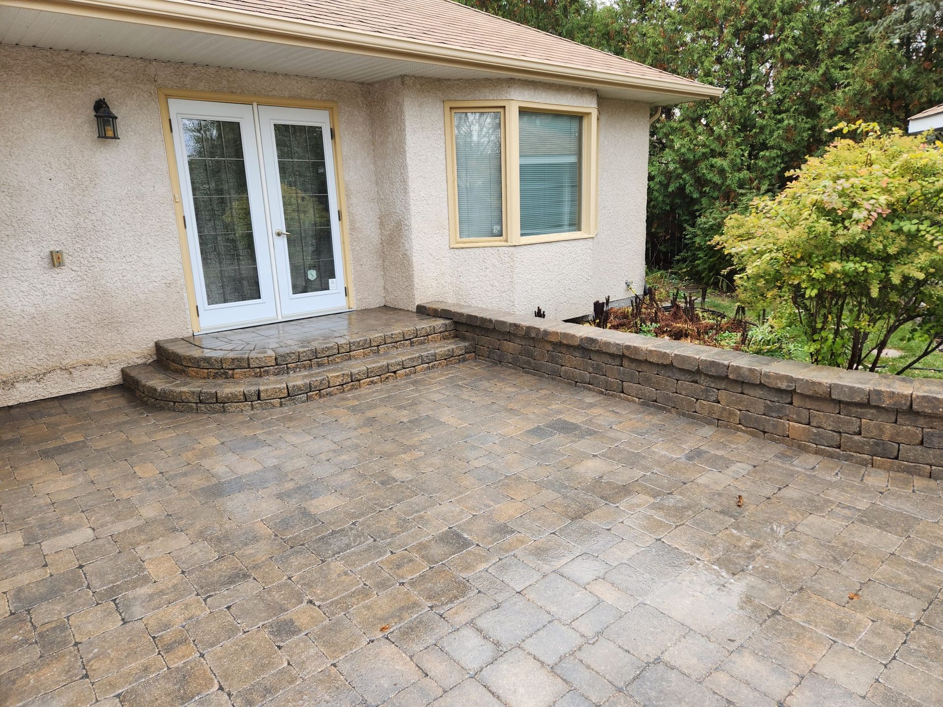 A house with a paver patio and stairs in front of it