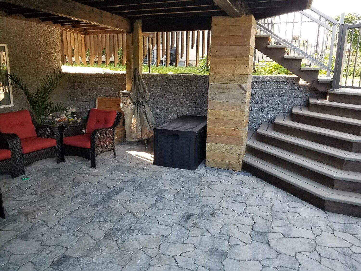 A patio with chairs , a table and stairs.