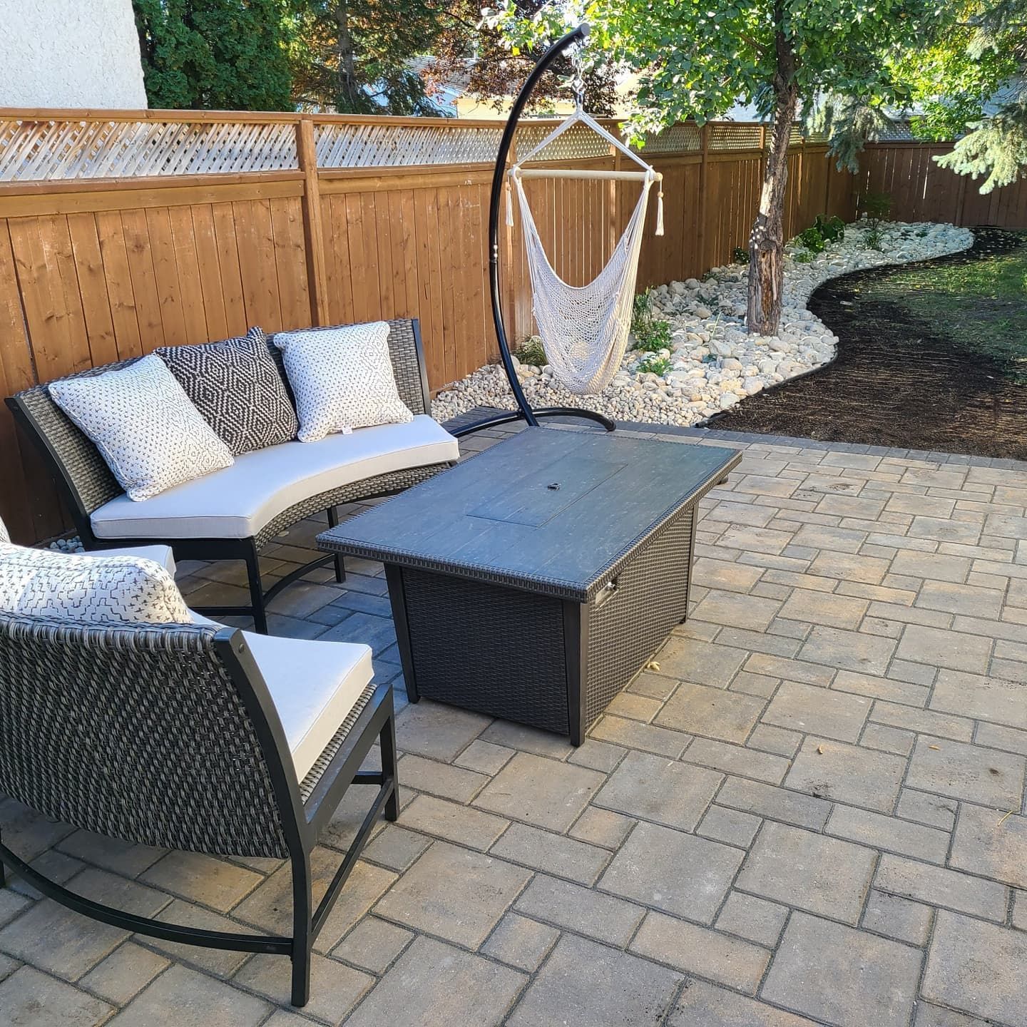 A patio with a bench and chairs and a hammock