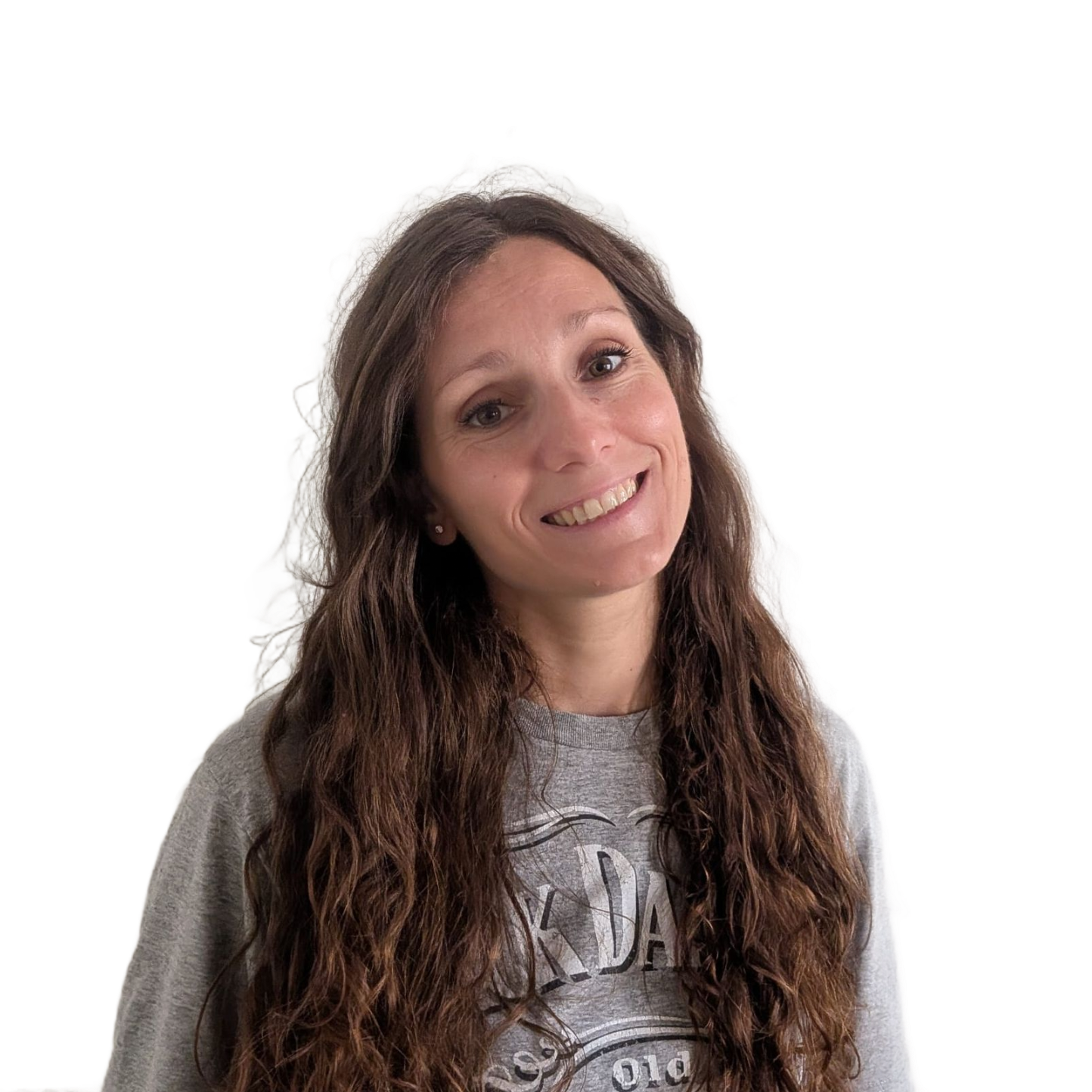 Donna sorridente con lunghi capelli mossi che indossa una camicia grigia su sfondo bianco