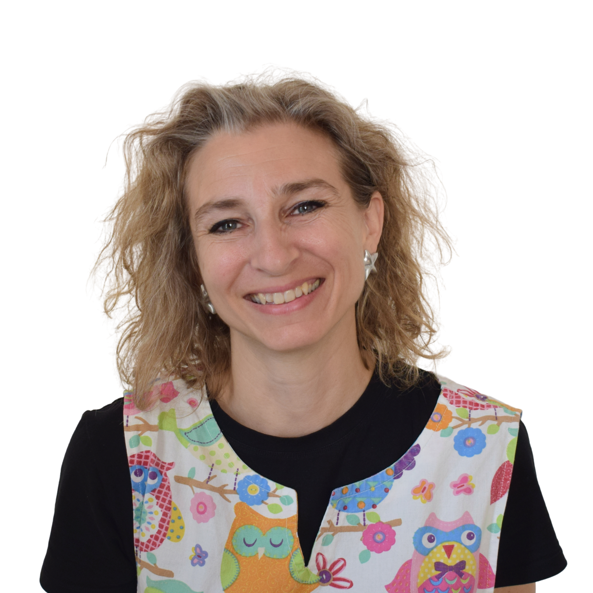 Persona sorridente con i capelli ricci che indossa un gilet colorato con motivo a gufo su sfondo bianco