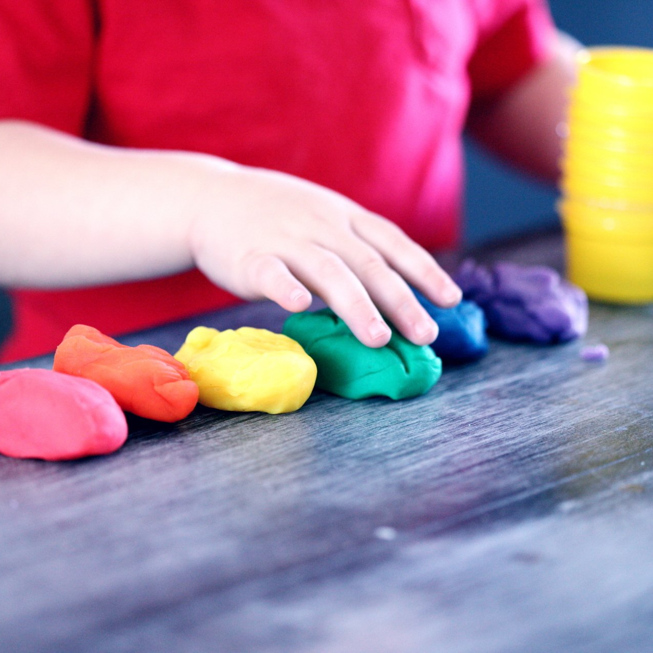 Bambino che modella argilla colorata su un tavolo