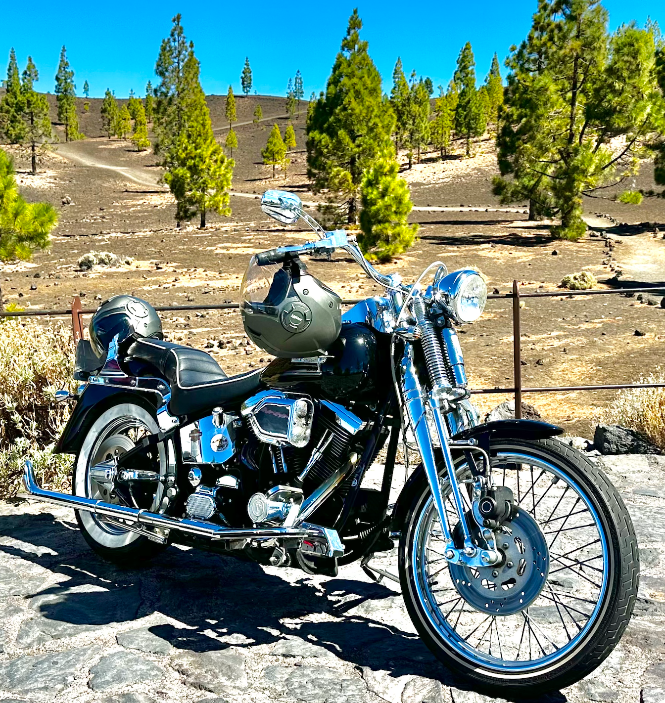 A motorcycle with a helmet on it is parked on the side of the road