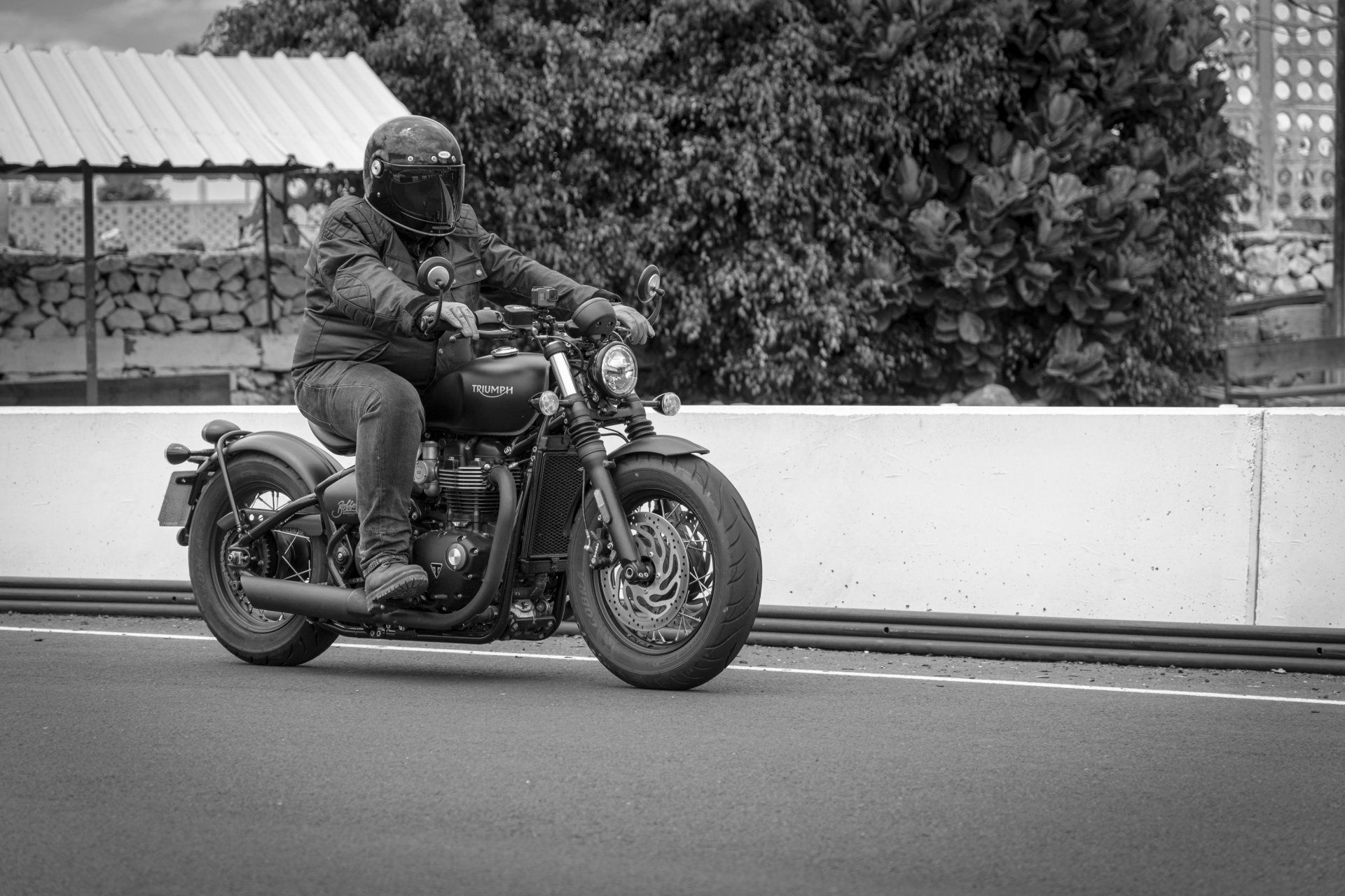 A man is riding a motorcycle down a road.