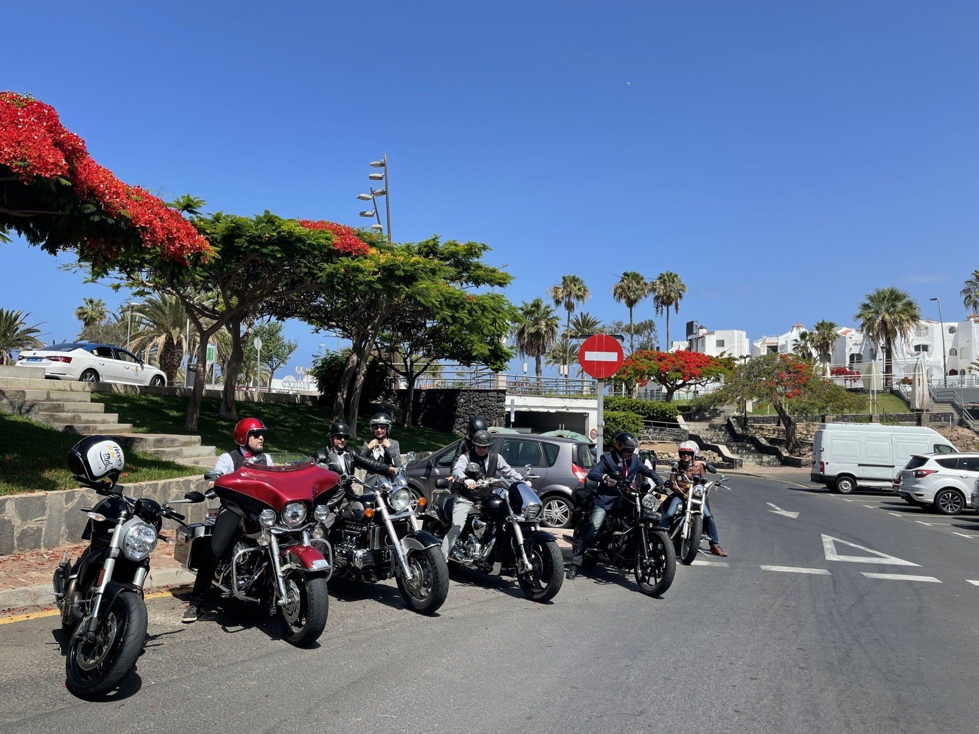 A group of motorcycles are parked on the side of the road.