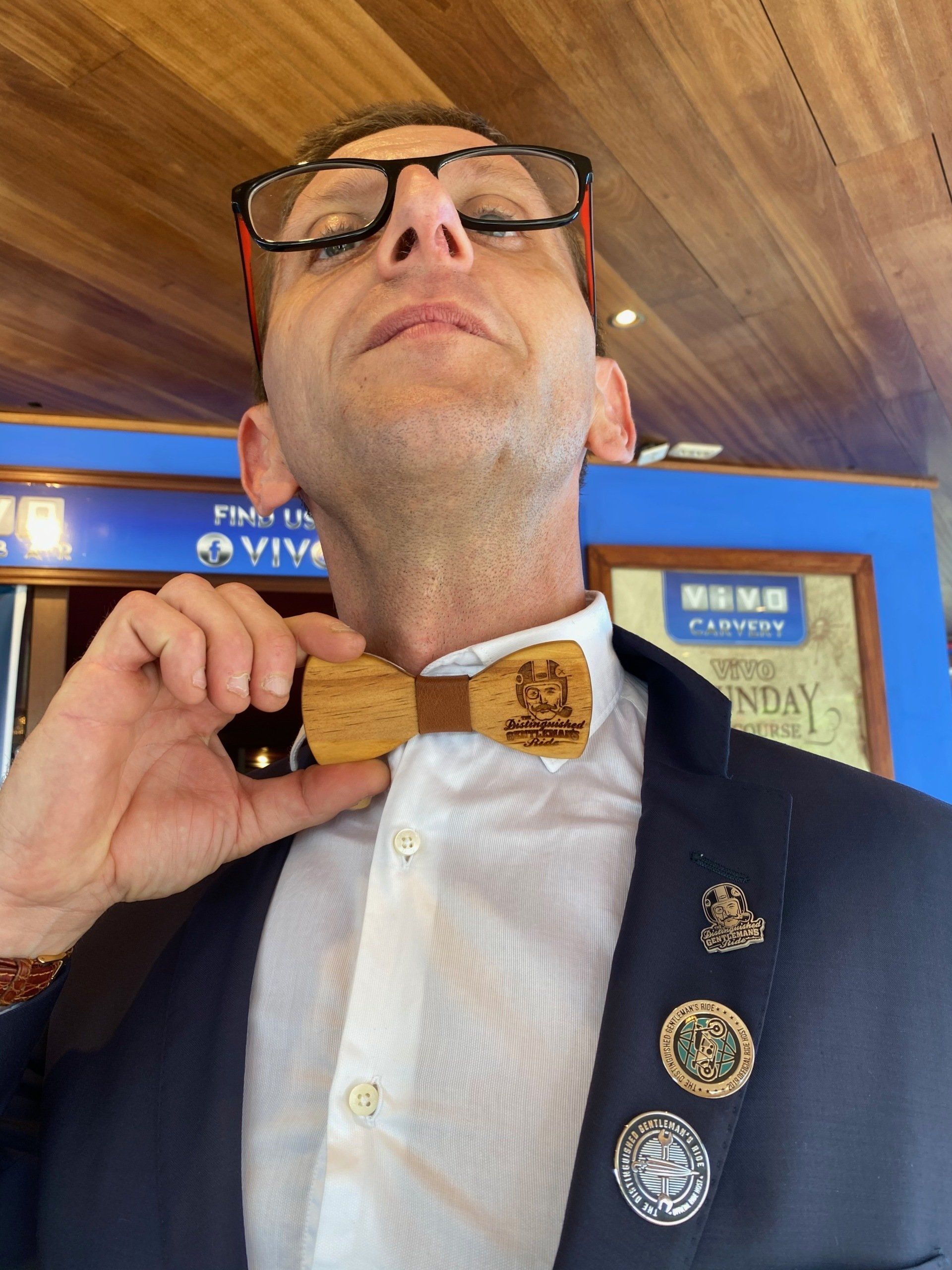 A man wearing glasses and a wooden bow tie
