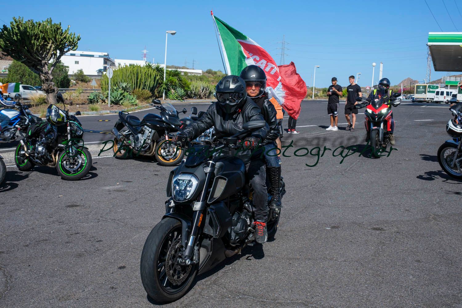A man is riding a motorcycle in a parking lot