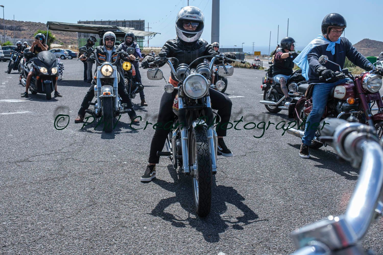 A group of people are riding motorcycles down a road.