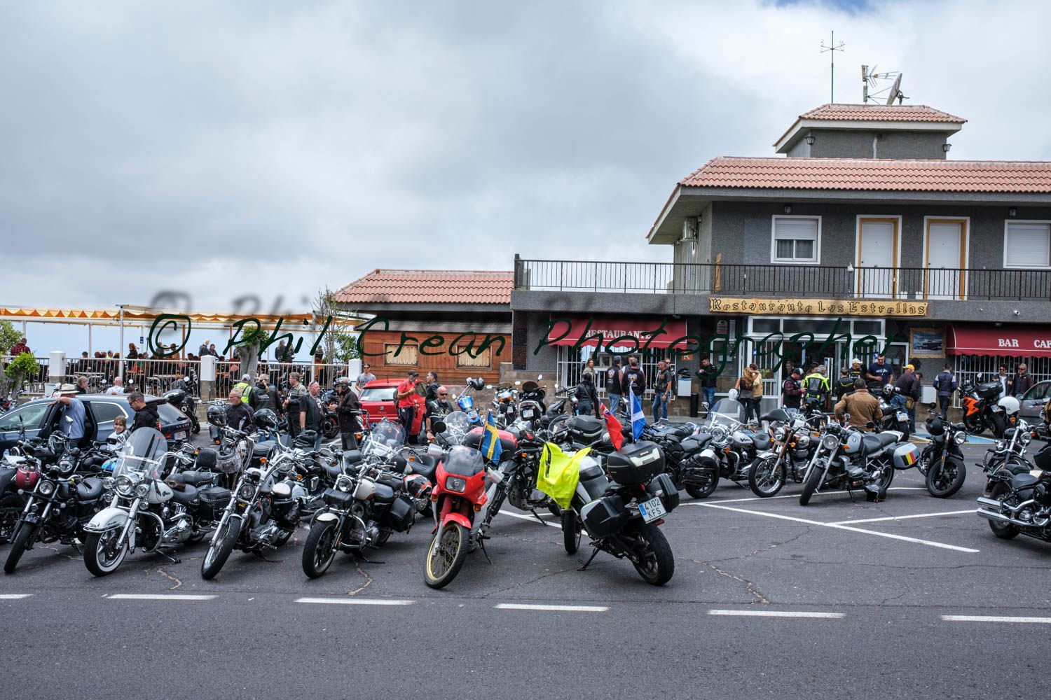 A large group of motorcycles are parked in front of a building.