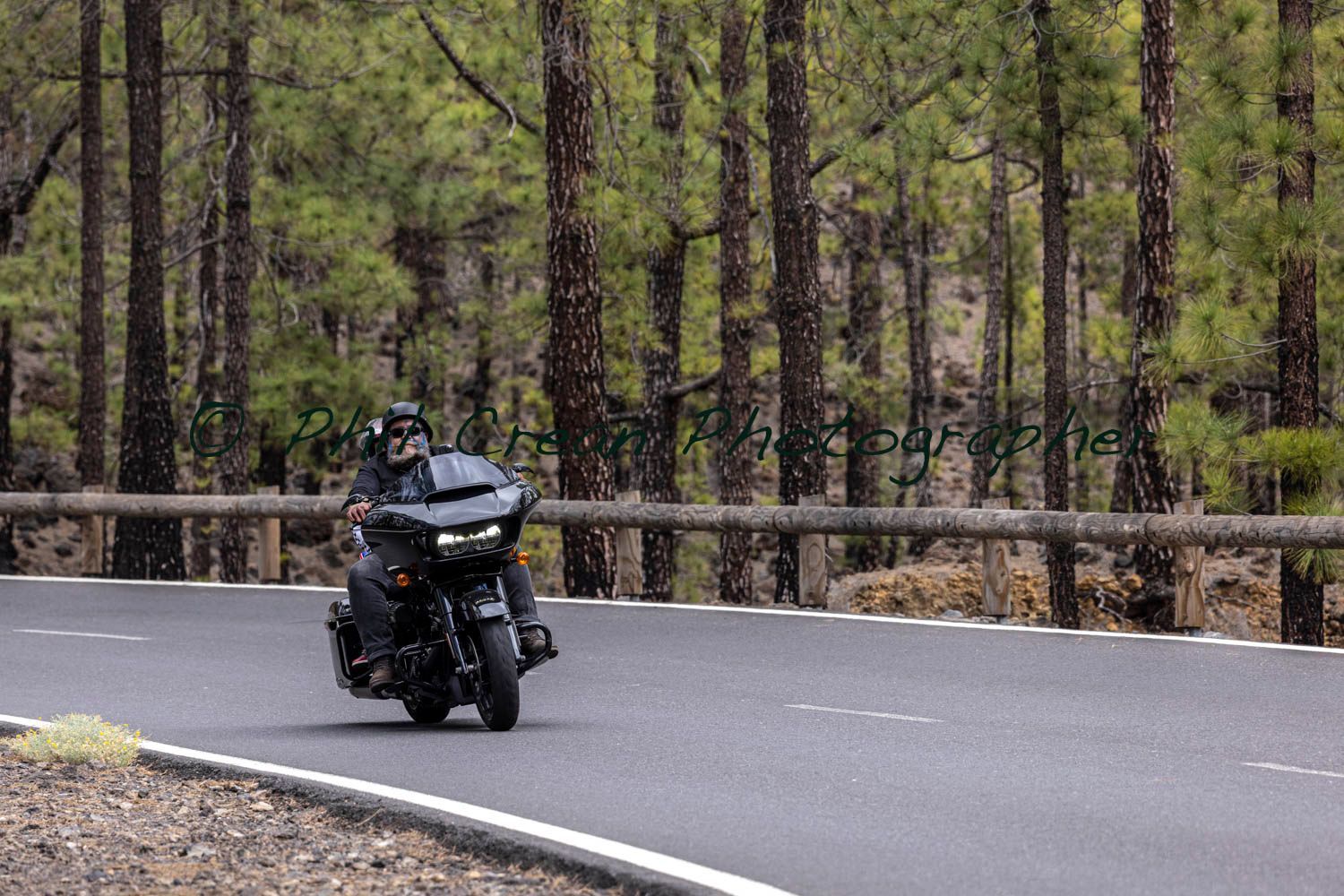 A man is riding a motorcycle down a curvy road.