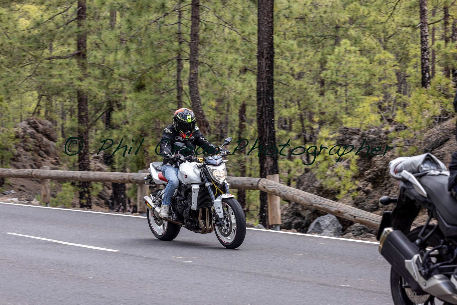 A man is riding a motorcycle down a road.