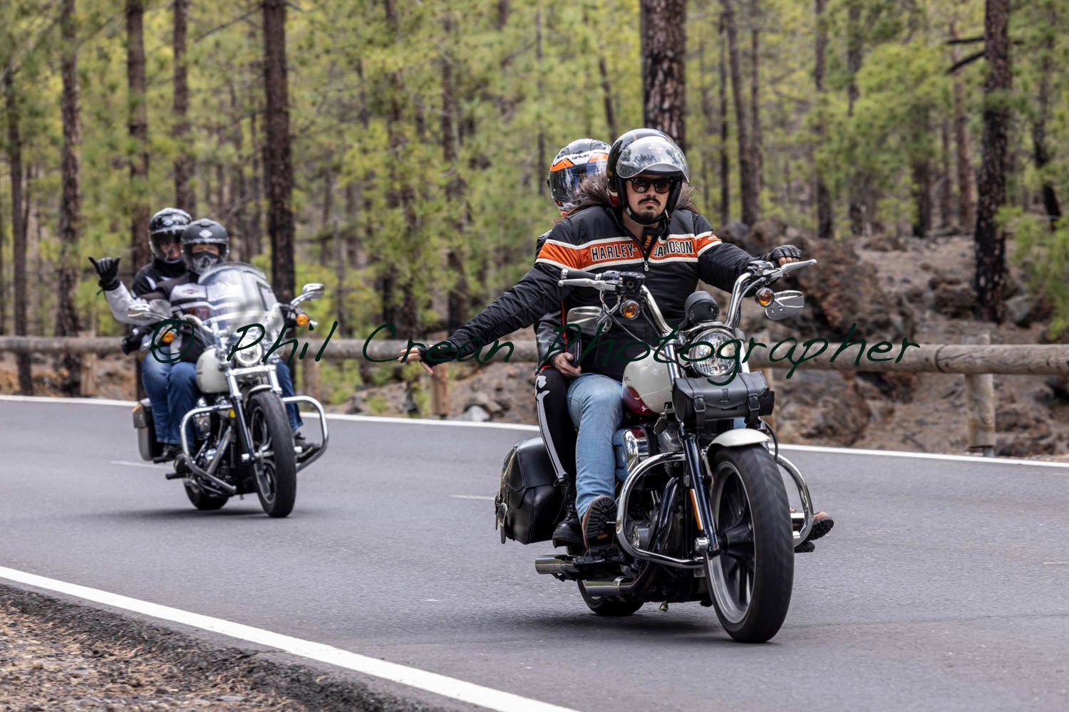 A group of people are riding motorcycles down a road.