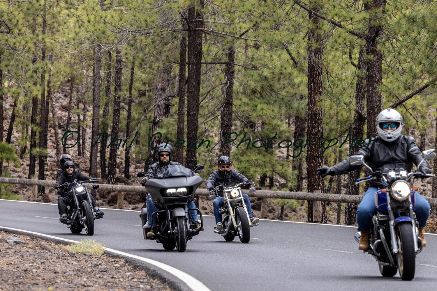 A group of people are riding motorcycles down a road.