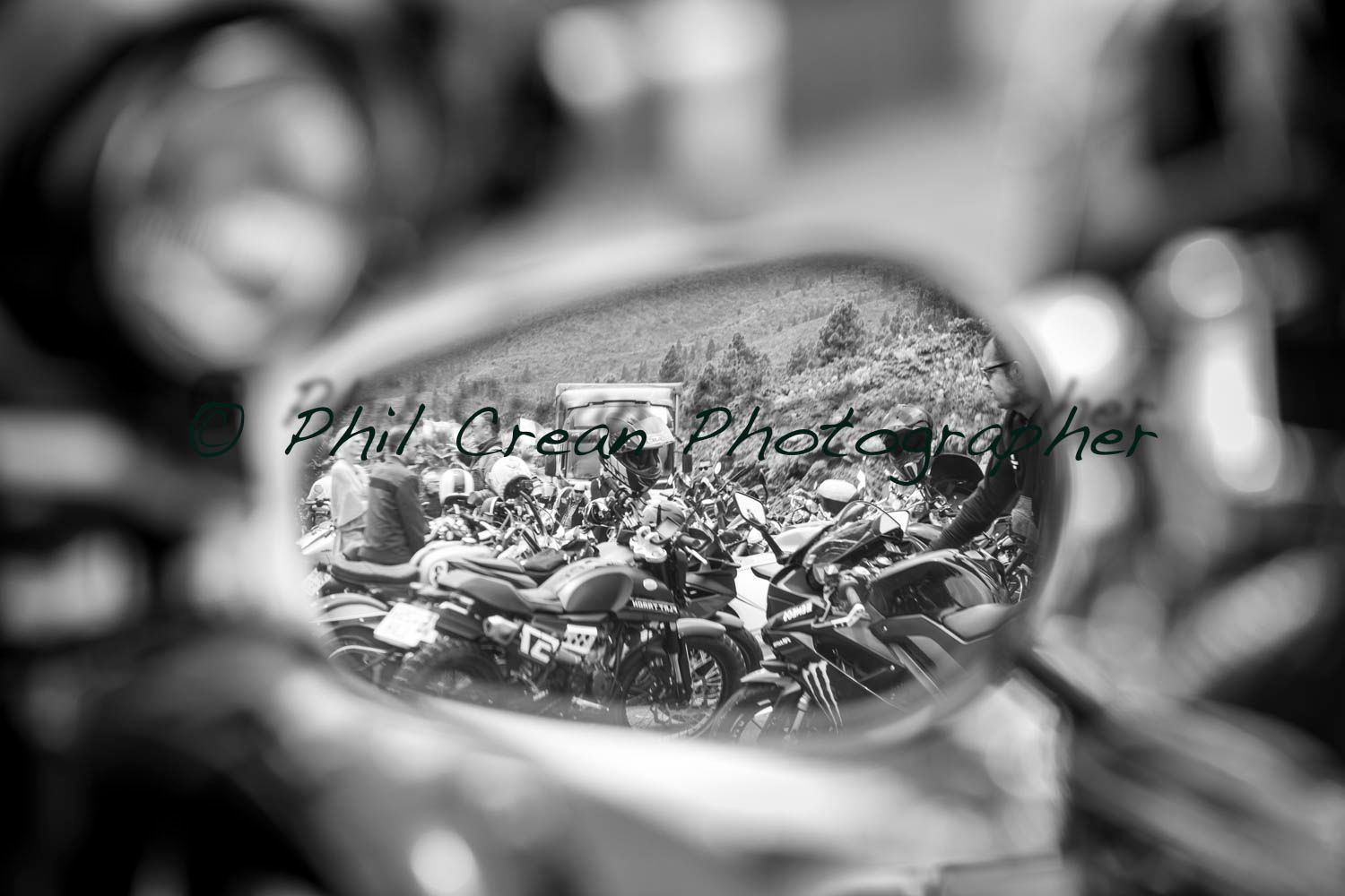 A black and white photo of a motorcycle rear view mirror