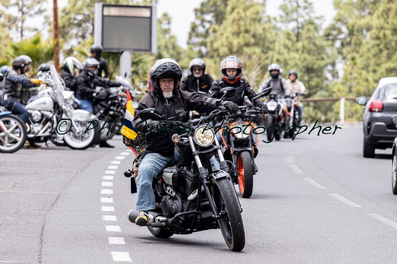 A group of people are riding motorcycles down a road.