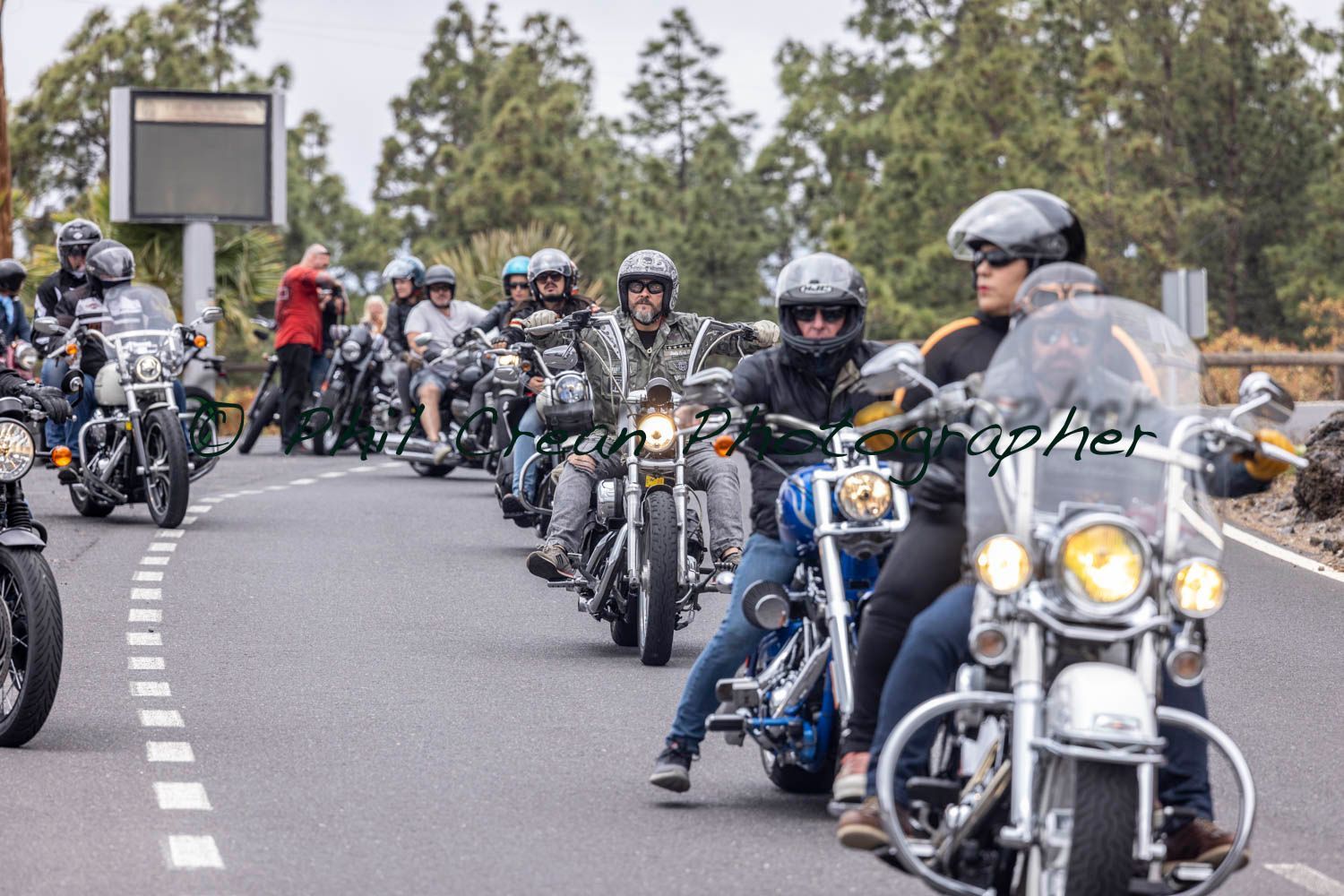 A group of people are riding motorcycles down a road.