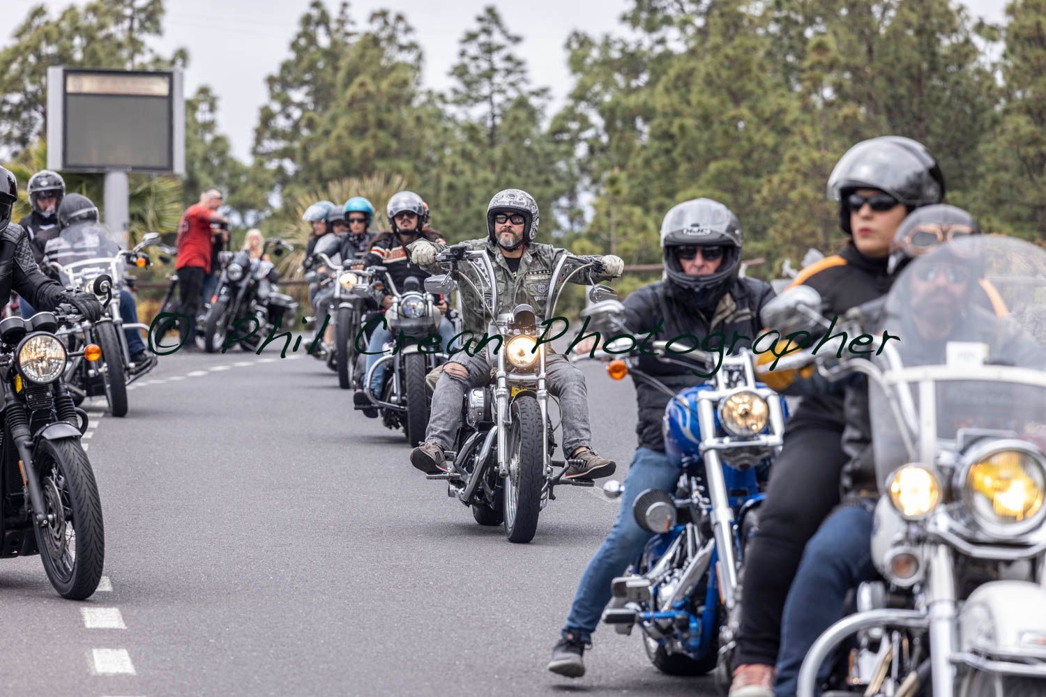 A group of people are riding motorcycles down a road.
