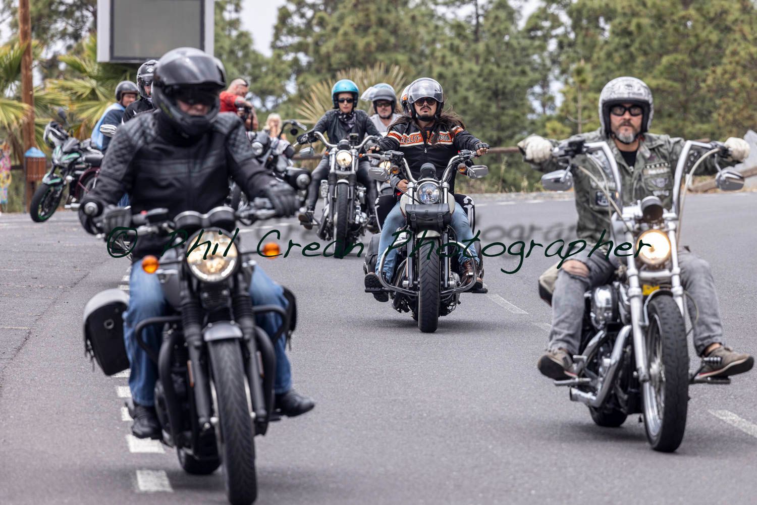 A group of people are riding motorcycles down a road.