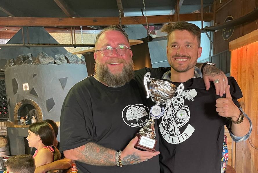 Two men are standing next to each other holding a trophy.