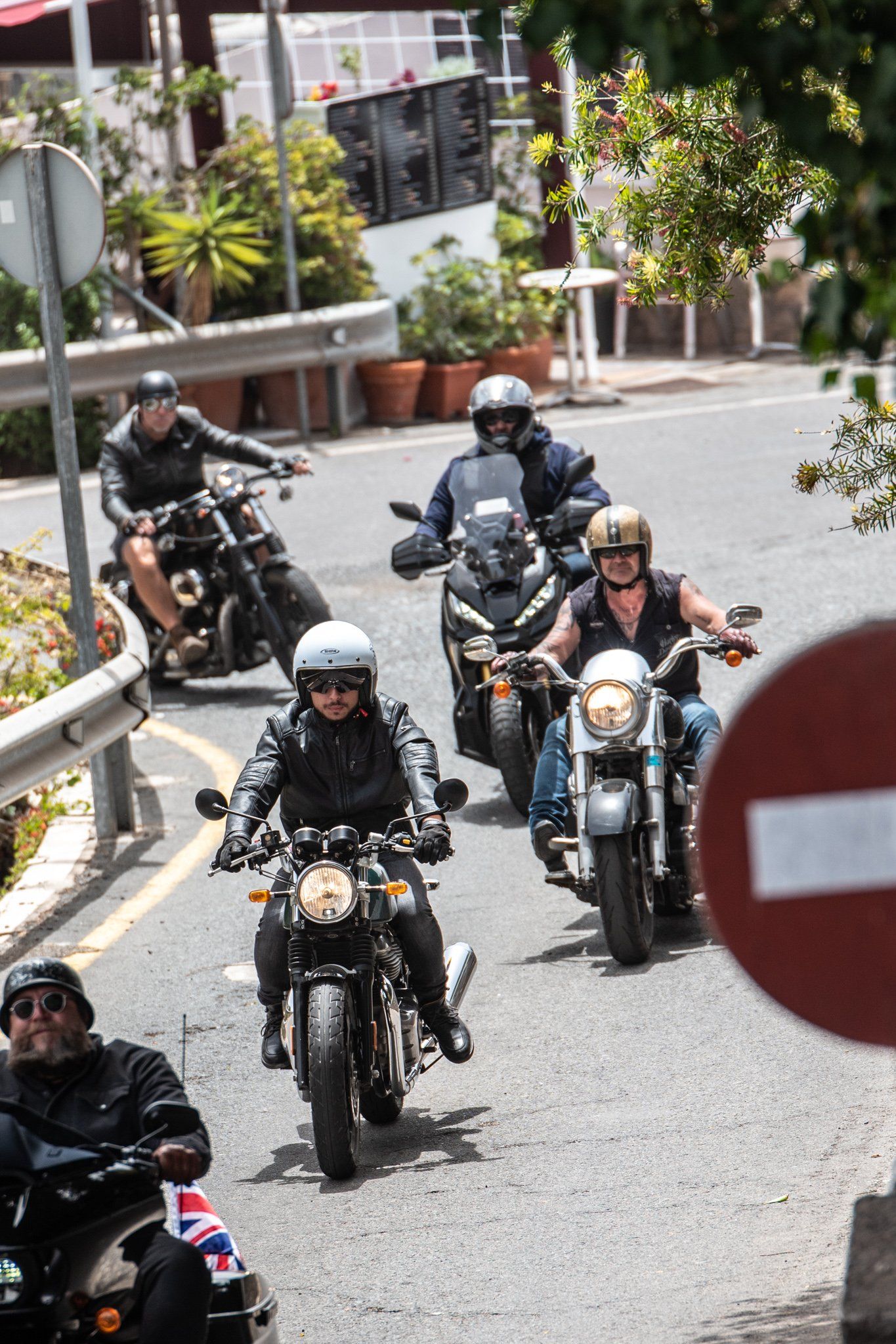 A group of people are riding motorcycles down a street.