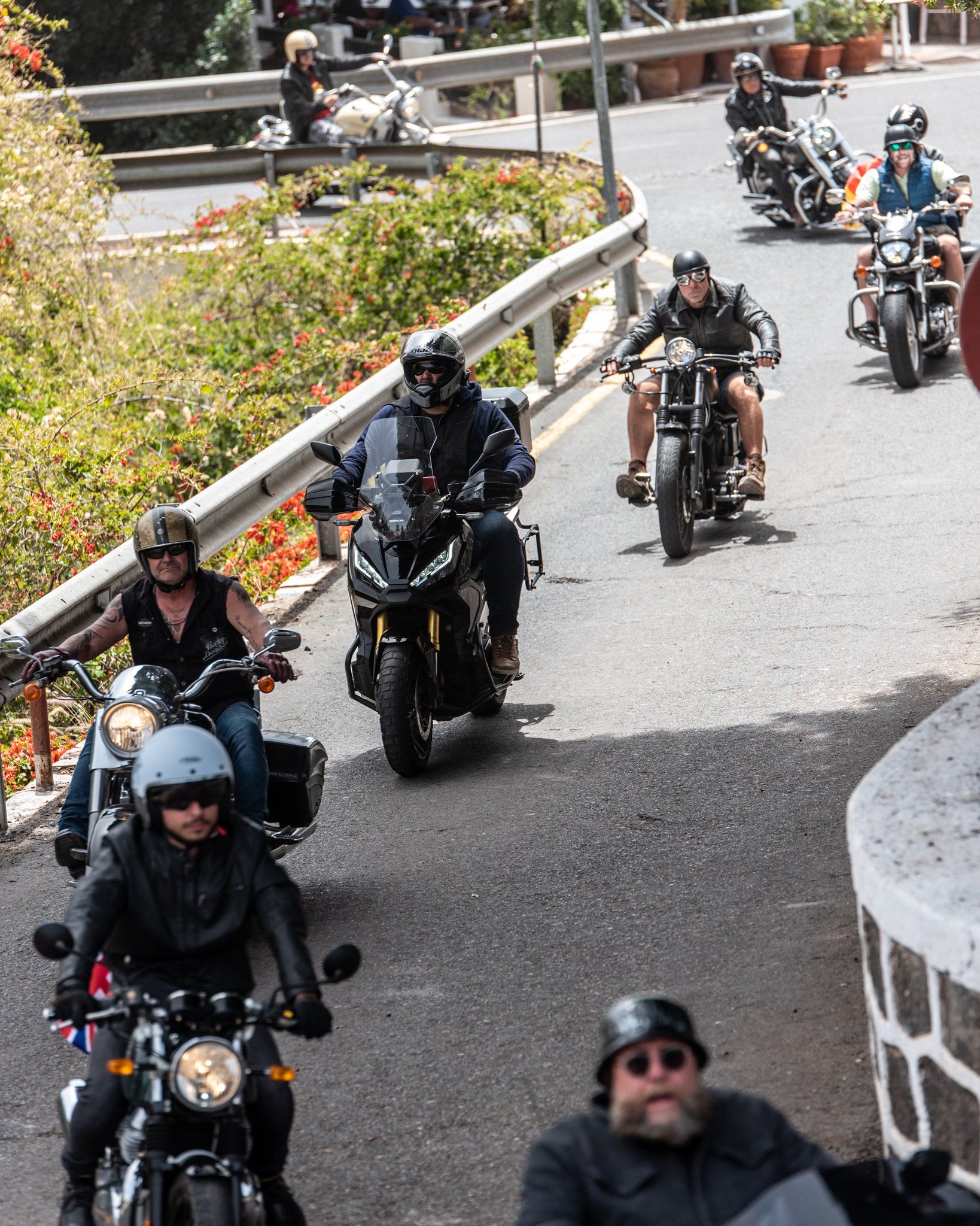 A group of people are riding motorcycles down a road