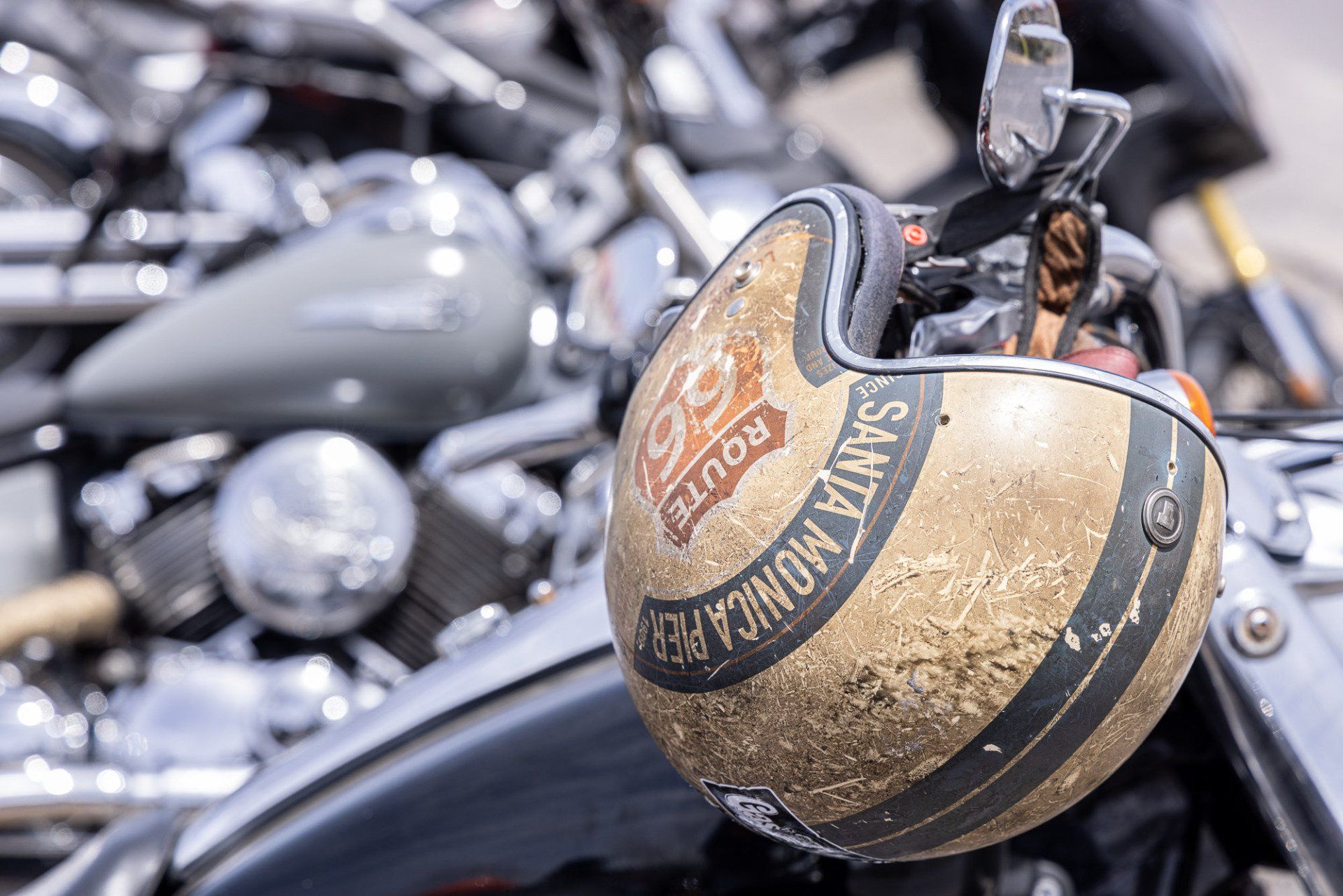A motorcycle helmet is sitting on the back of a motorcycle.