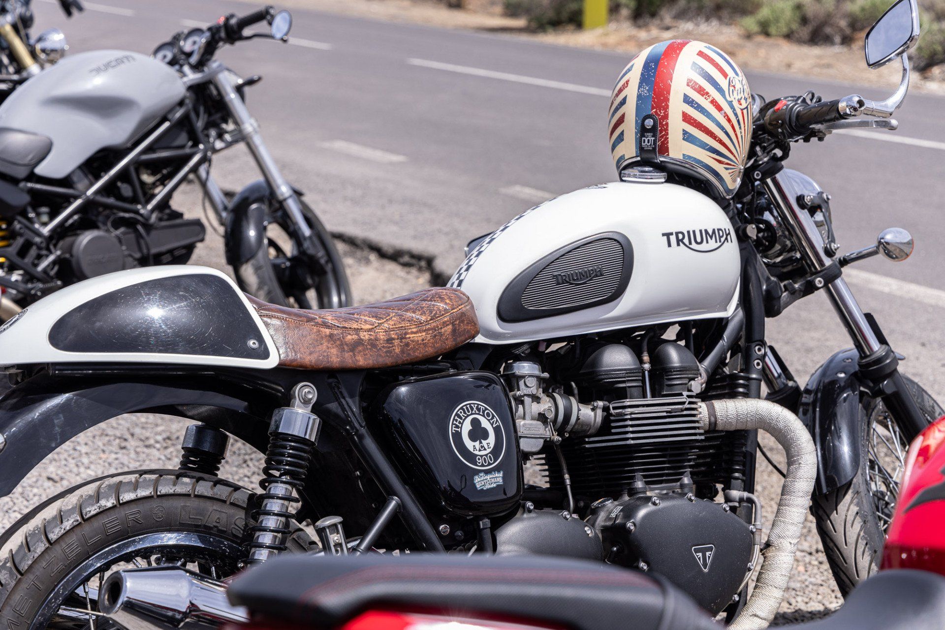 A triumph motorcycle is parked on the side of the road